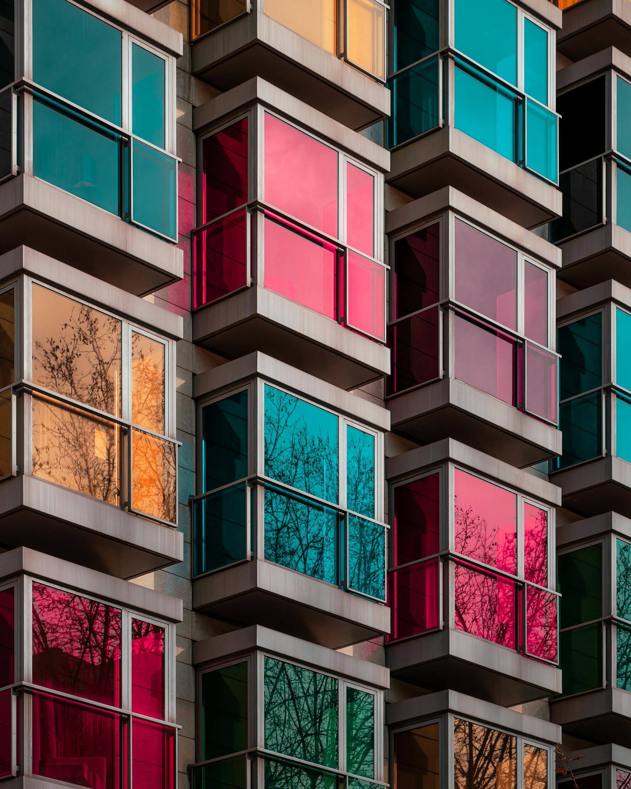 Vibrant colored glass balconies on a modern apartment building facade in Bilbao, Spain.